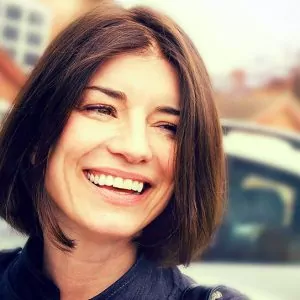 A woman smiling proudly with straight teeth.